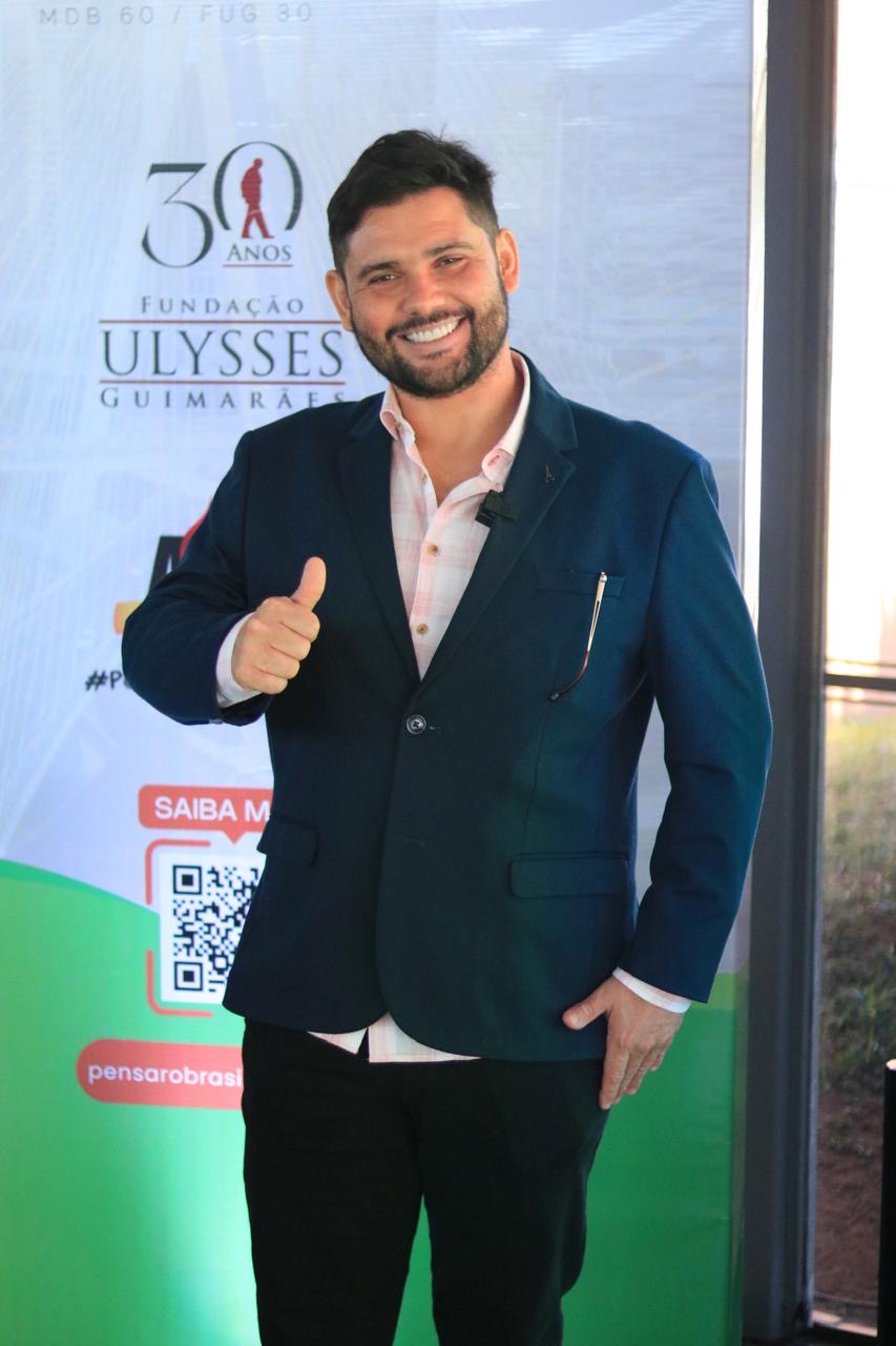 Caio do Vovô Anésio de terno, fazendo sinal de positivo